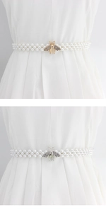 Détail de la boucle abeille avec strass sur ceinture élastique en perles blanches
