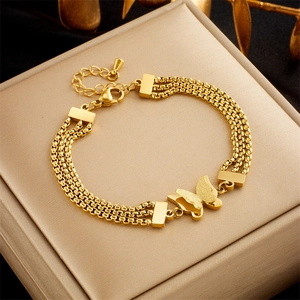 Detail view of a gold multi-layer chain bracelet featuring elegant butterfly charms