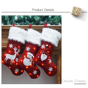 Close-up of LED glowing Christmas stockings featuring plush reindeer and snowman patterns