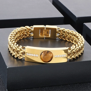 Vue macro d'un bracelet en acier inoxydable avec pierre oeil de tigre et zircons