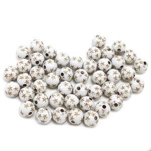 Macro detail of white acrylic round beads with gold star pattern and center hole for DIY