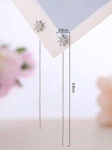 Detail view of silver star tassel earrings with white rhinestones and length measurements