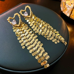 Elegant gold heart earrings with zircon inlay and sparkling tassel chains on black stand