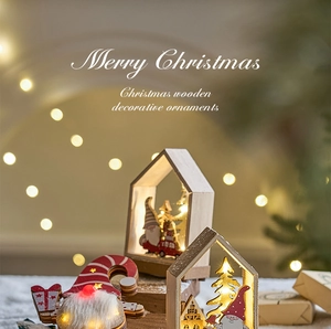 Close-up of wooden Christmas village ornament with LED lights and festive gnome