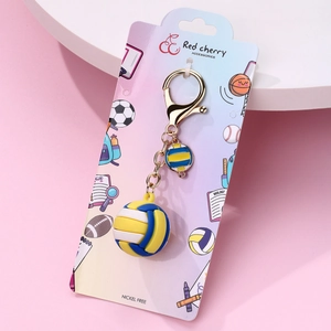 Detail of blue and yellow volleyball keychain with metal ring and graphic card packaging