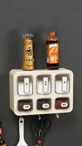 Detail of wall-mounted kitchen spice rack with six drawers and integrated hanging hooks