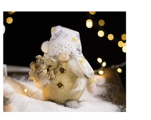 Detail of white snowflake knit hat and golden sequin body on a Christmas gnome doll