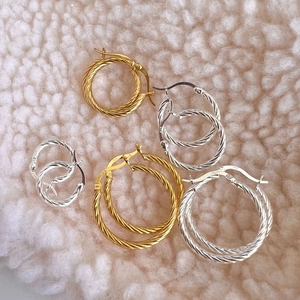 Detailed view of twisted 925 silver hoop earrings in gold and silver variety sizes