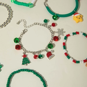 Flat lay of festive Christmas bracelets featuring reindeer, bells, and Santa charms