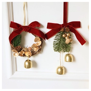 Detail of Christmas wreath with red velvet bow, pine cones and gold bells ornaments