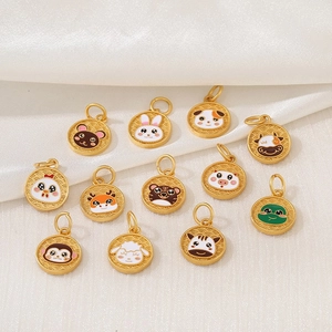 Set of twelve gold-plated Chinese zodiac pendants with cute animal designs on white fabric
