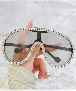 Close-up of oversized luxury aviator sunglasses with sparkling rhinestone-encrusted frame