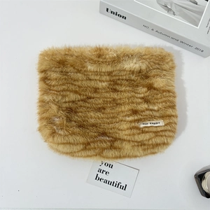 Detail of plush leopard print makeup bag featuring a soft texture and brand label