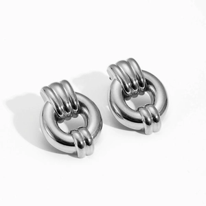 Close-up of silver geometric hoop earrings with polished finish and ribbed texture