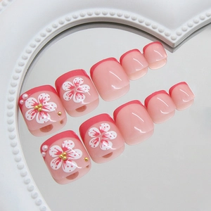 Französische Lilien-Perlen-Zehennägel mit Kirschblüten-Design auf einem Herztablett