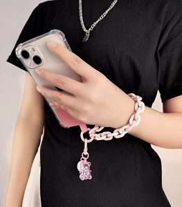 Pink and white acrylic chain wrist strap with purple bear charm on a black outfit
