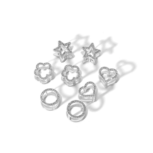 Macro view of silver geometric hair rings with zircon in star, heart, and flower shapes