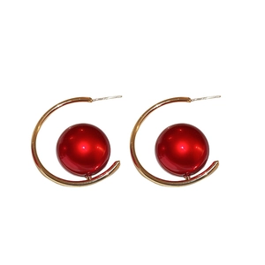 Vintage French style C-shaped gold earrings with a bold red resin pearl on white background