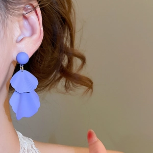 Close-up of elegant purple double-layered flower petal earrings worn by a model