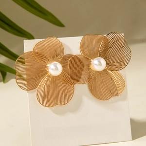 Vue détaillée de boucles d'oreilles pétales dorés avec perle centrale et design ajouré