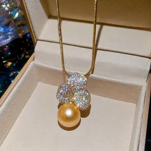 Elegant gold plated clover flower pendant necklace with a large golden pearl and zircons