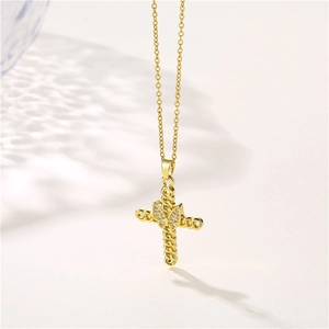 Collana con croce in acciaio inossidabile dorato con farfalla e zirconi su sfondo bianco
