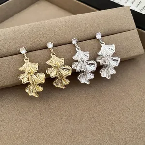 Elegant ginkgo leaf stud earrings in gold and silver finish with sparkling zircon stones
