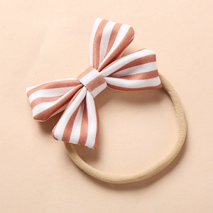 Detail of soft nylon baby headband with a striped bow and premium fabric texture