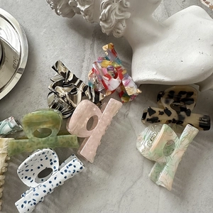 Detail showing multiple marble and tortoiseshell acetate hair claws on a stone surface