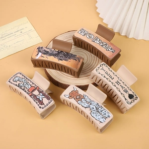 Western style hair claws with Yee Haw and Wild Heart patterns on wood and paper
