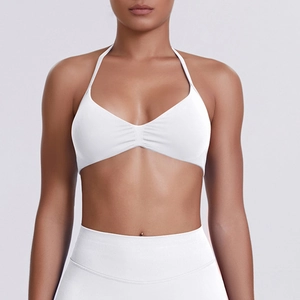 Detail of white halter neck sports bra with ribbed texture and minimalist front ruched design
