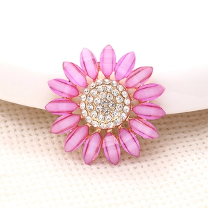 Macro shot of a pink sunflower accessory with sparkling crystals and golden alloy trim