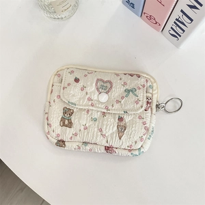 Detailed view of quilted cream pouch with cute bear floral print and key ring