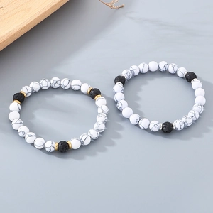 Detail of volcanic stone and white marble beaded bracelets with gold and silver spacers