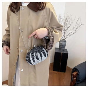 Fashionable zebra print clutch bag with silver chain strap shown with a trench coat