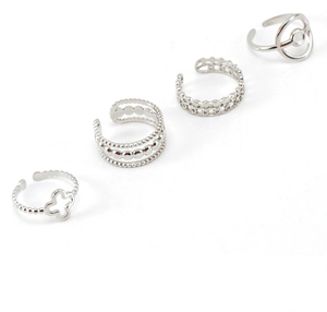 Detail of four silver adjustable rings featuring four-leaf clover and beaded textures