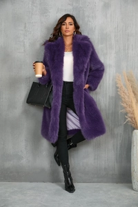 Dettaglio della trama di un cappotto viola in finta pelliccia di volpe su una modella