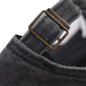 Detail of the vintage brass adjustable metal buckle on a charcoal washed cotton baseball cap