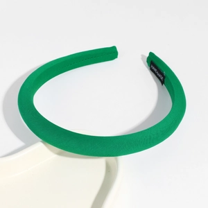 Detailed close-up of a handmade fruit green fabric headband on a ceramic tray