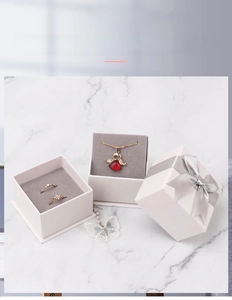 White jewelry gift box with silver ribbon and grey velvet lining for rings and necklaces