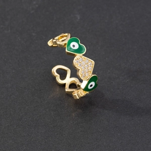 Macro shot of gold adjustable open ring featuring green enamel evil eye heart and zircons