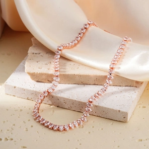Rose gold tennis necklace with marquise-cut cubic zirconia on champagne silk background