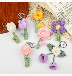 Detailed overhead shot of various handmade crochet flower keychains on a rustic table
