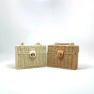Detail of woven square handbags in beige and brown with golden metal twist locks