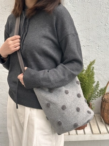 Secchiello in feltro a pois con pompon 3D mostrato con una tracolla casual quotidiana