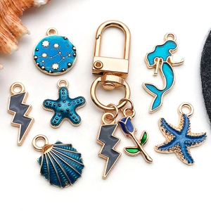 Blue enamel ocean themed jewelry charms set with mermaid starfish and shell pendants