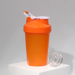Detail of orange shaker bottle showing protein mixer ball and leak-proof flip cap lid