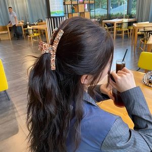 Detailed view of an amber tortoiseshell hair claw clip securing a hair bun hairstyle