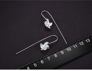 Macro shot of S925 sterling silver windmill earrings with ruler showing 5cm length