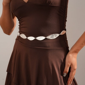 Close-up of vintage silver leaf waist chain with hammer texture on a brown dress